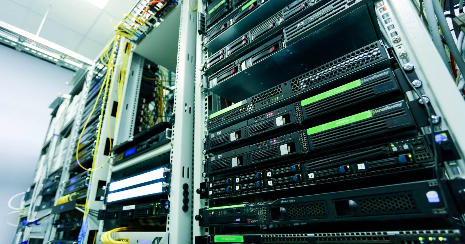 Pasillo de un centro de datos con bastidores de servidores y cables de red