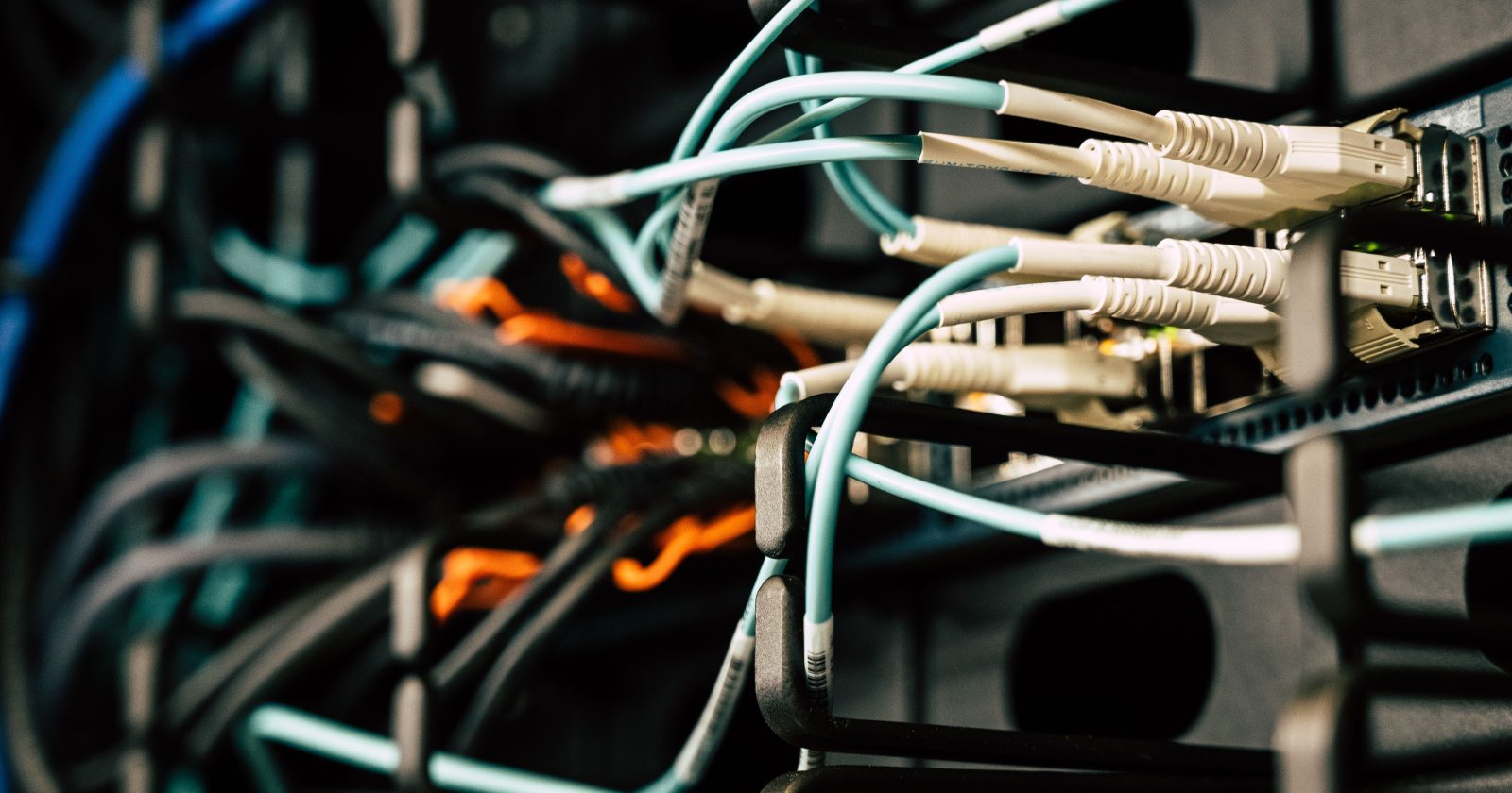 Cables enredados conectados a equipos dentro de una sala de servidores
